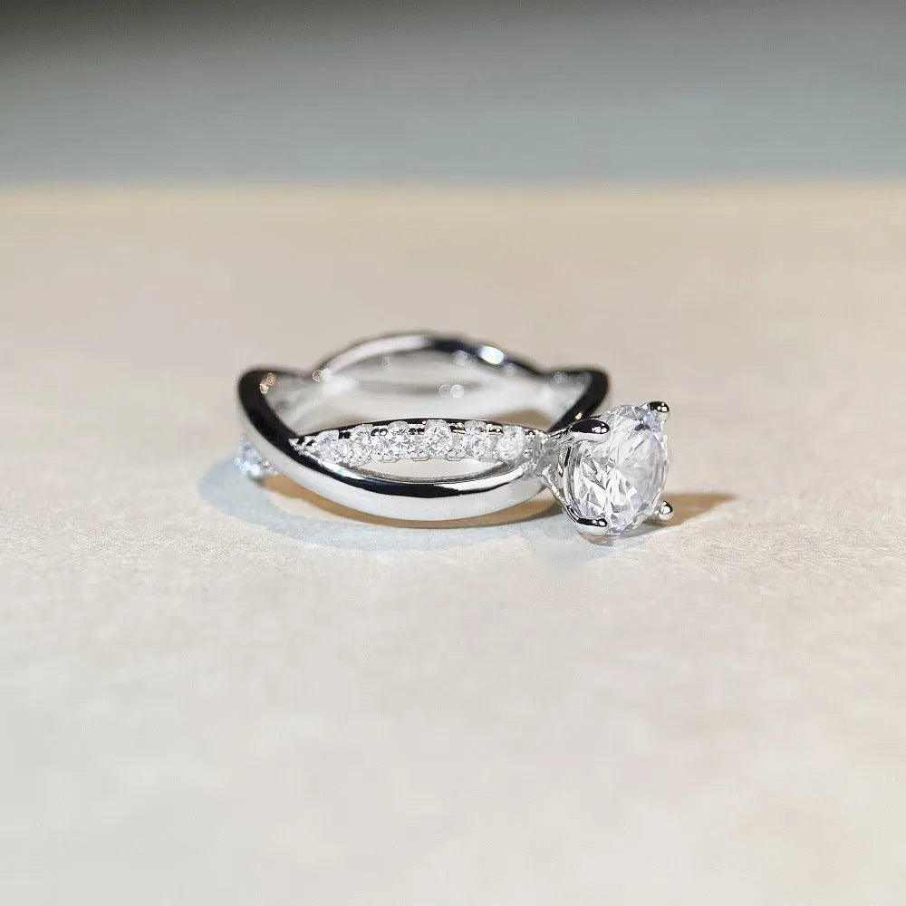 Geometric silver ring with a 1 karat moissanite stone in a four-claw setting and twisted arm band.
