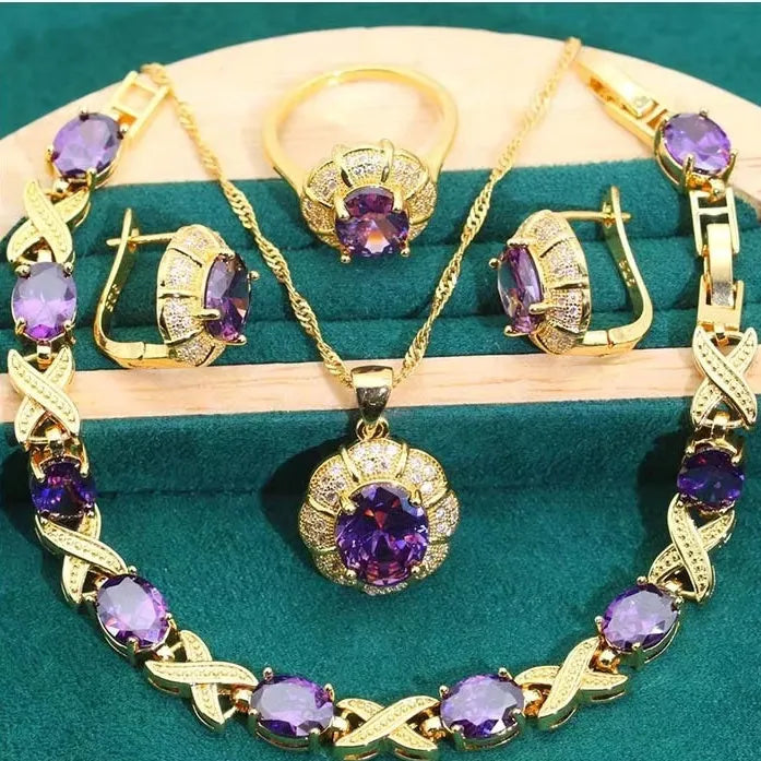 18k gold plated jewellery set showing ring, earrings, bracelet, and necklace with coloured cubic zirconia stones.