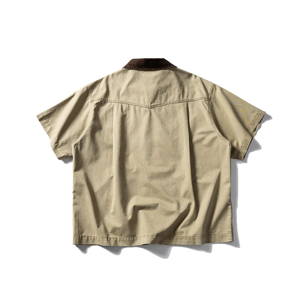 A khaki-coloured, short-sleeved overalls shirt with a loose cardigan style on a hanger.