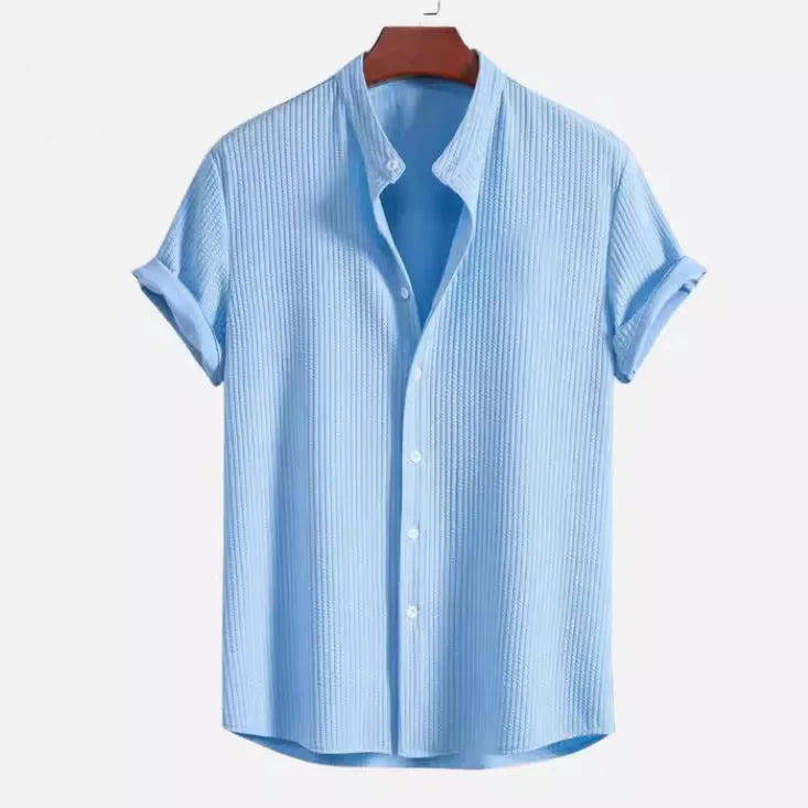 Man wearing a loose-fitting short sleeve summer shirt in a solid colour, showing the relaxed fit and short sleeves.