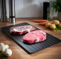 Black aluminium quick defrosting tray for thawing frozen meat and food without electricity.