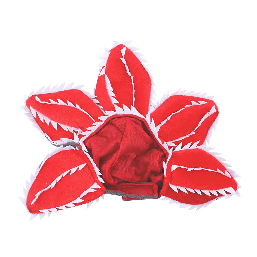 Dog wearing green and red Halloween chomper costume with demon hat headband and colourful flowers