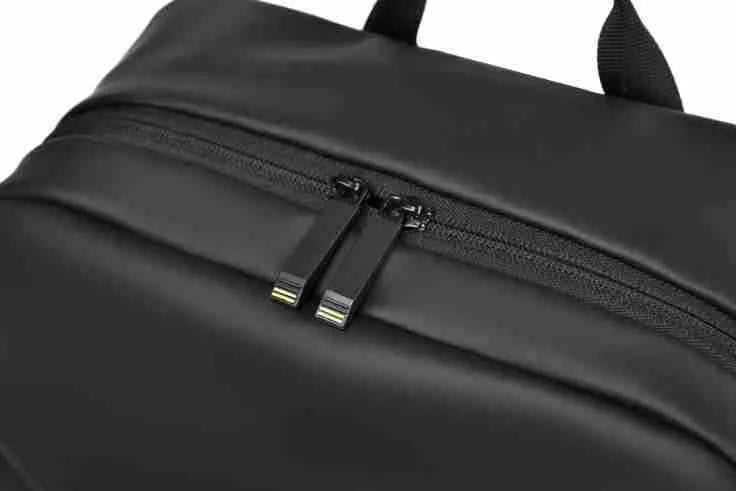 Men's large waterproof black PU leather backpack with laptop compartment on a grey background.