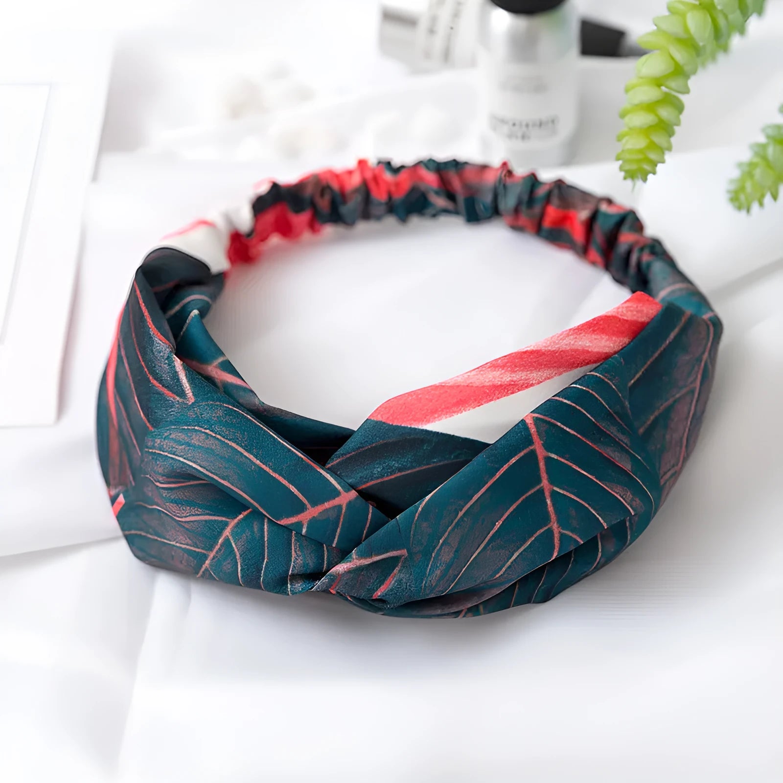 Red cloth headband with banana leaf pattern for women, showing elastic band construction