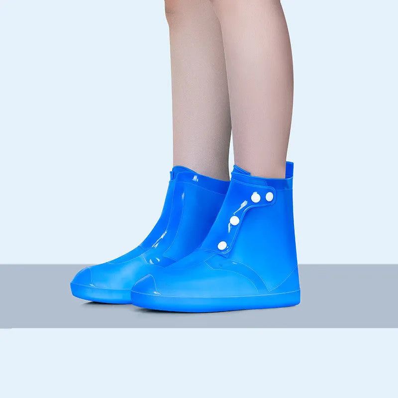 White high-top PVC reusable shoe covers for women on a rainy day background.