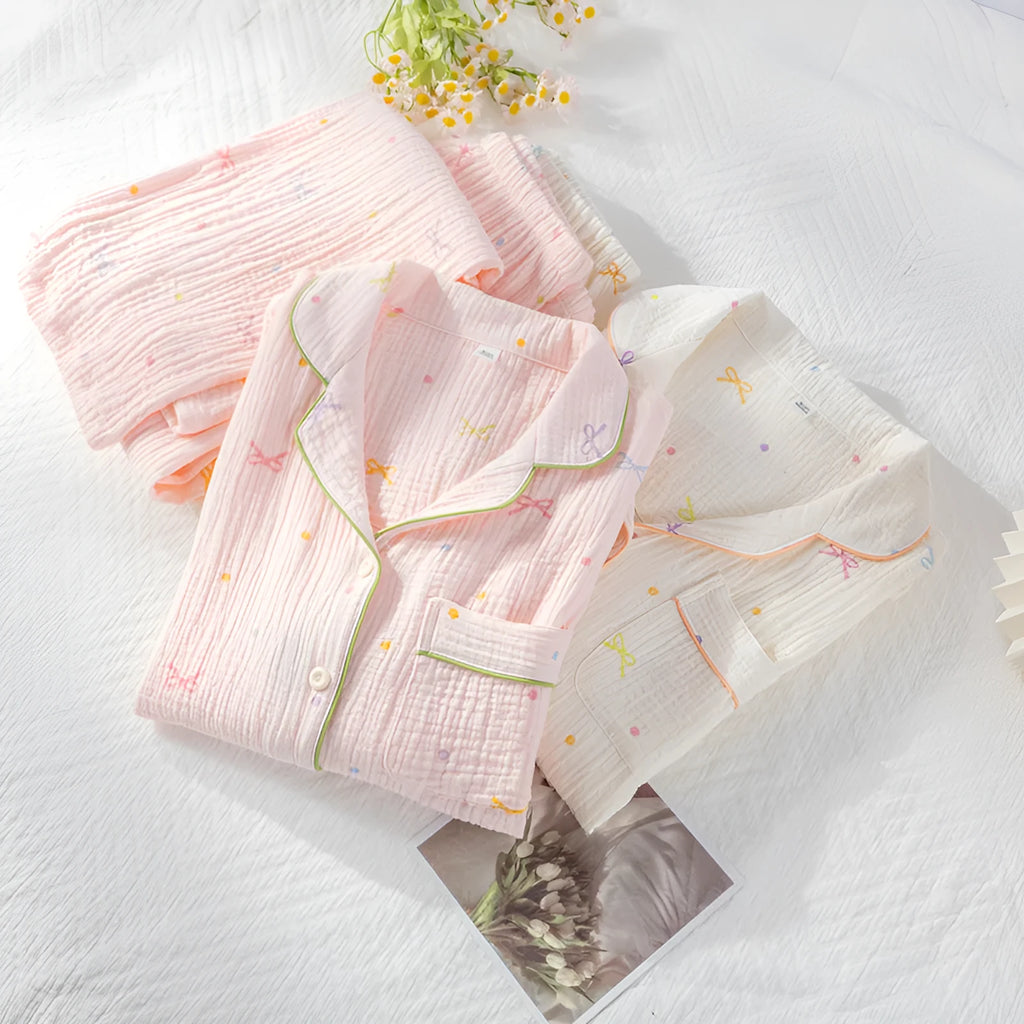 Women's beige long-sleeved cotton pajama top and trouser set laid flat.