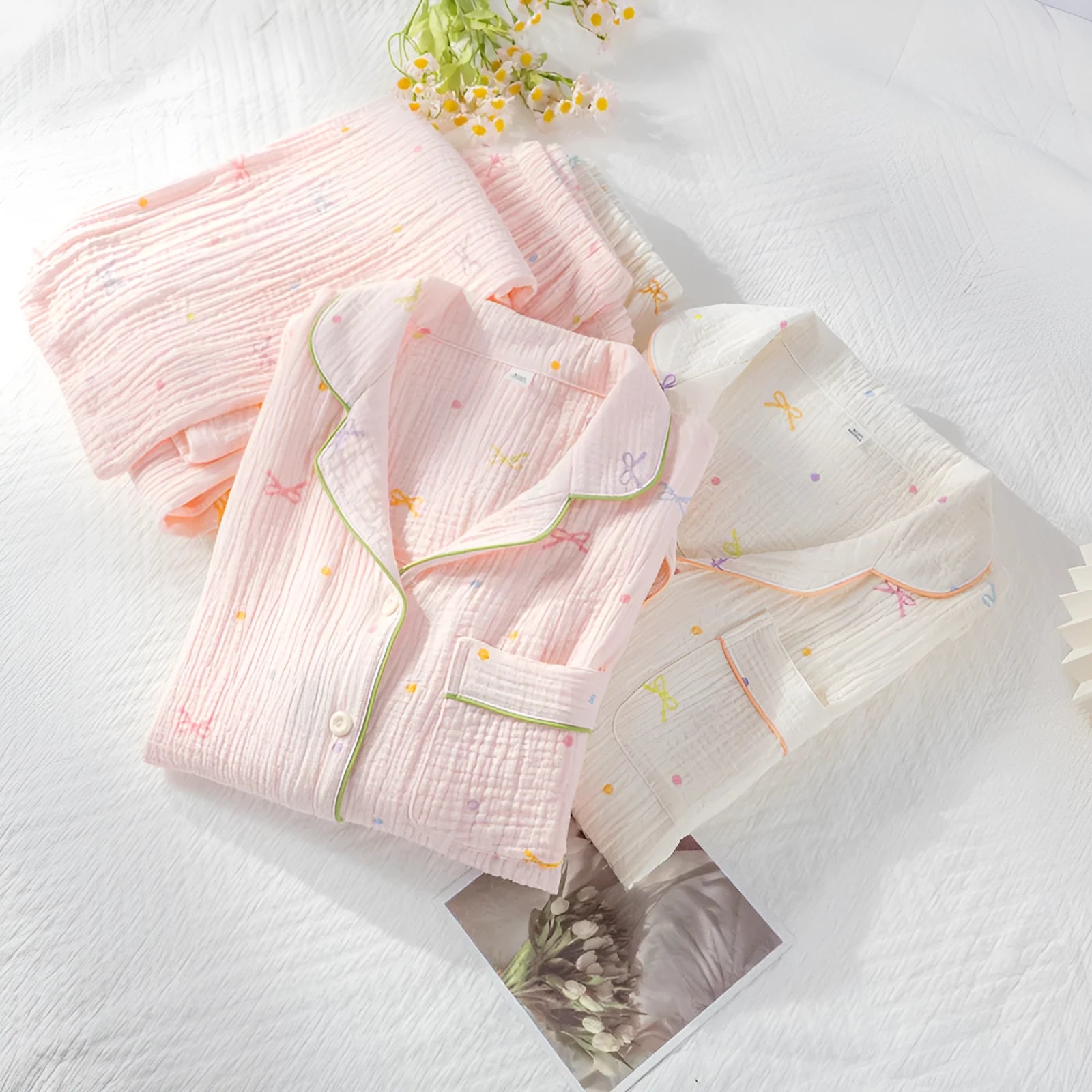 Women's beige long-sleeved cotton pajama top and trouser set laid flat.