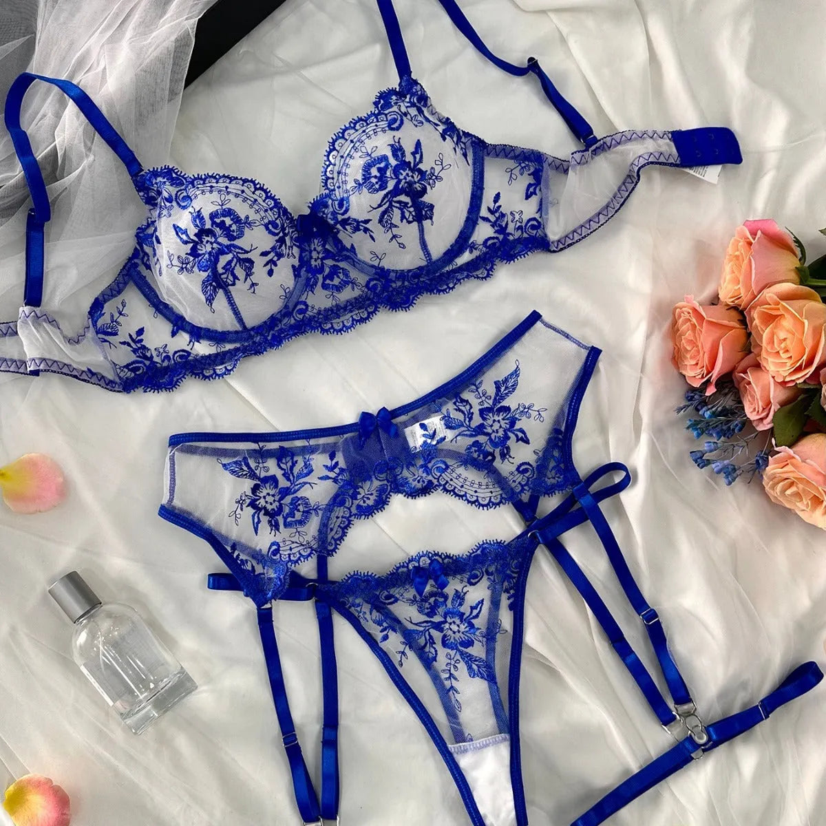 Sapphire blue see-through women's underwear suit with embroidery and cutouts, shown with matching thong and black suspenders.
