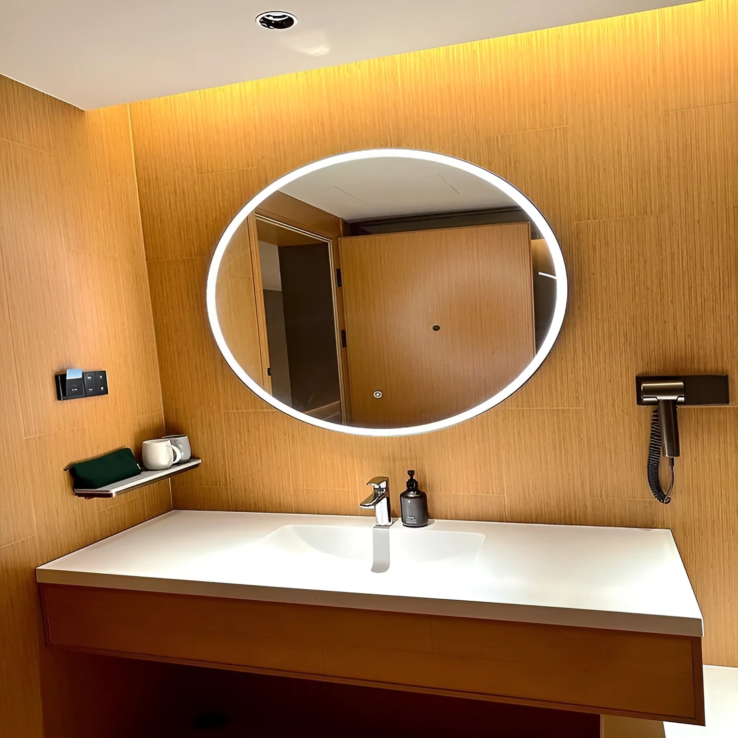 Round black framed LED bathroom mirror mounted on wall with dimmable lights.