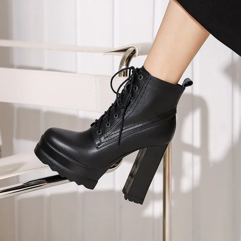 Women's black waterproof platform boots with a chunky heel and side zip fastening on a white background.