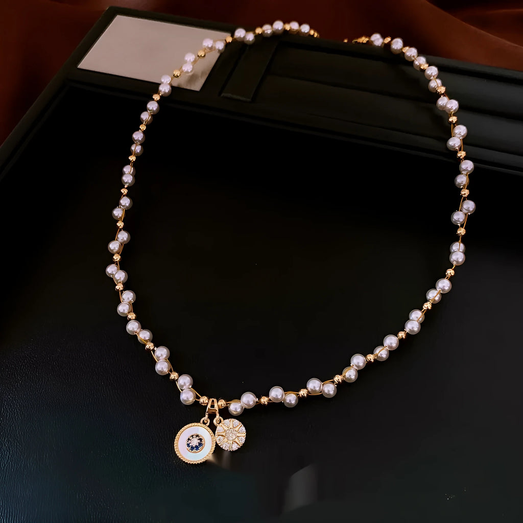 Gold electroplated necklace with round imitation pearl pendant and Chinese style geometric design