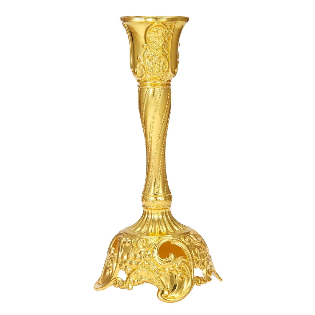 Small metal retro candlestick ornament in gold finish on a table