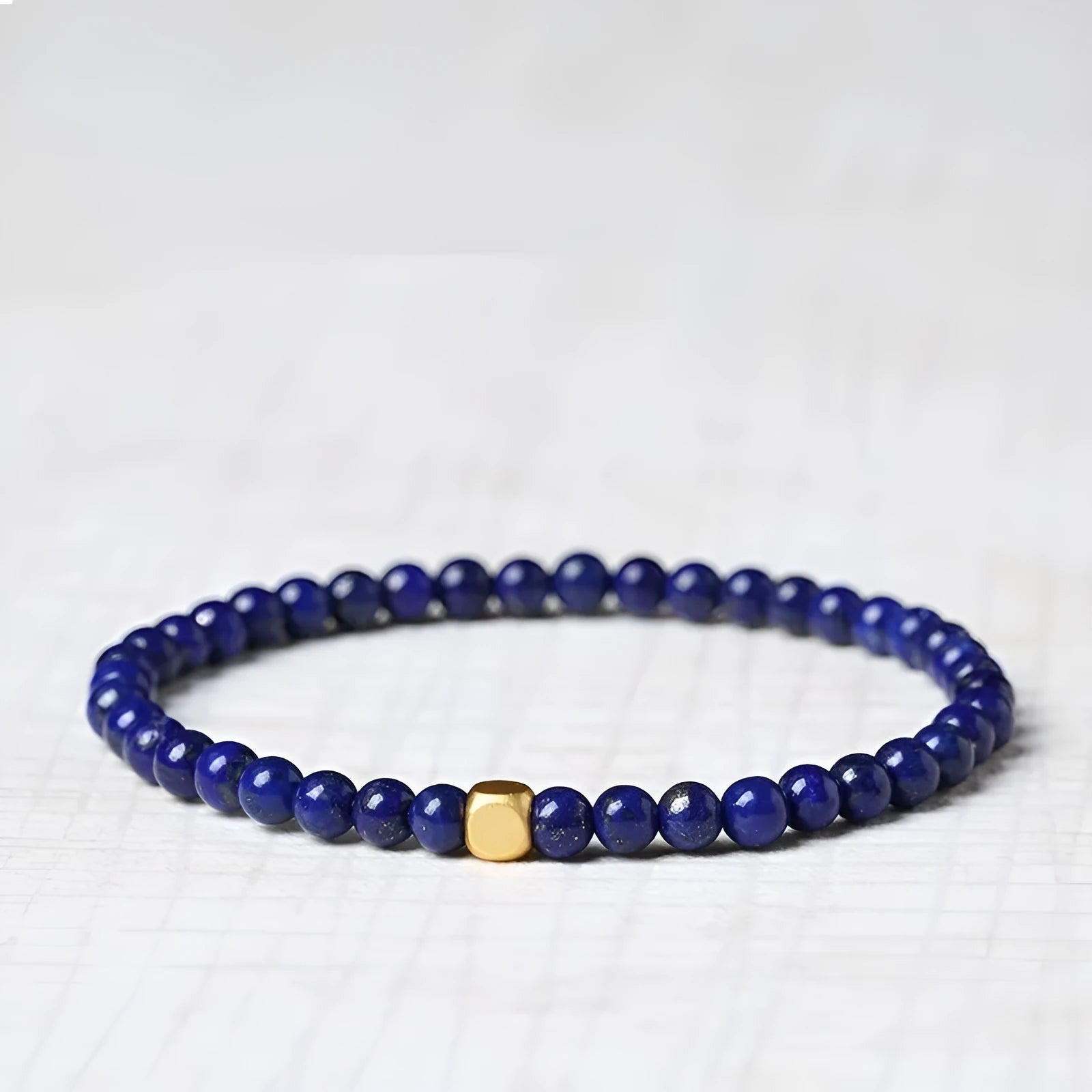 Close-up of a women's bracelet with a large 16mm geometric green gold stone crystal bead.
