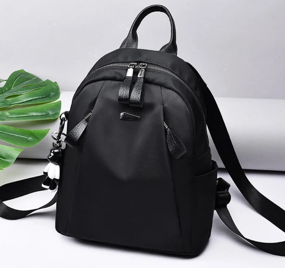 Medium square Oxford cloth rucksack in wine red with double straps and a front patch pocket.