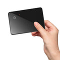 Black card-shaped pet tracker with wireless charging and NFC, showing hanging hole.