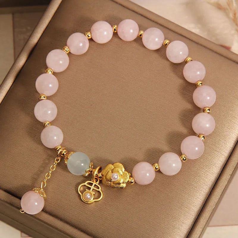 Women's pink crystal flower bracelet with clear crystal stones forming floral design pattern.