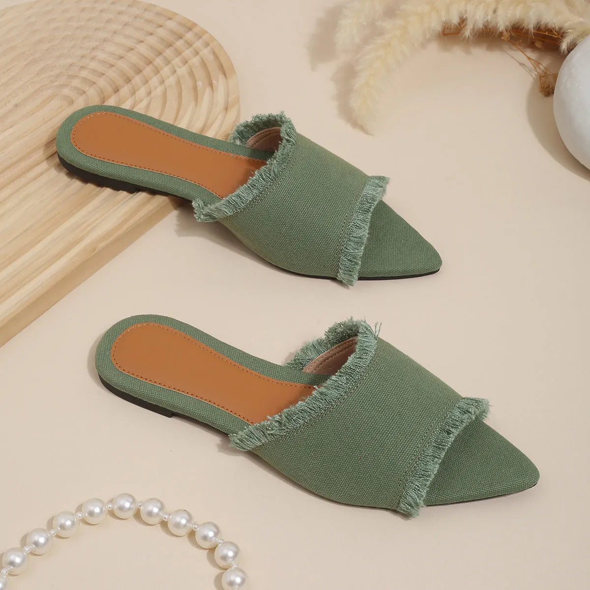 Women's flat denim slippers with a tassel detail in apricot colour on a white background
