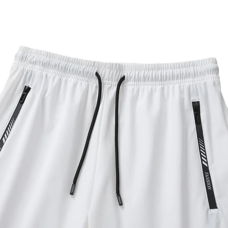 Man wearing black loose-fit quick-drying nylon sports shorts with an elastic waistband.