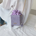 Small black women's chain-strap messenger shoulder bag with a bucket shape and zip opening.