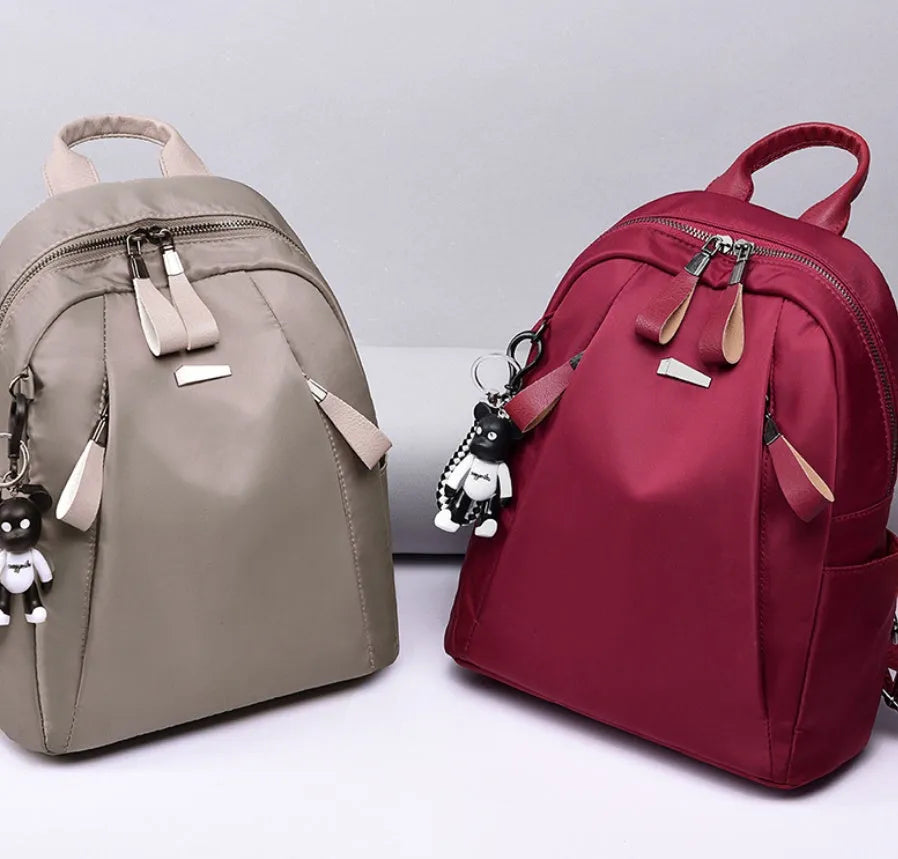 Medium square Oxford cloth rucksack in wine red with double straps and a front patch pocket.