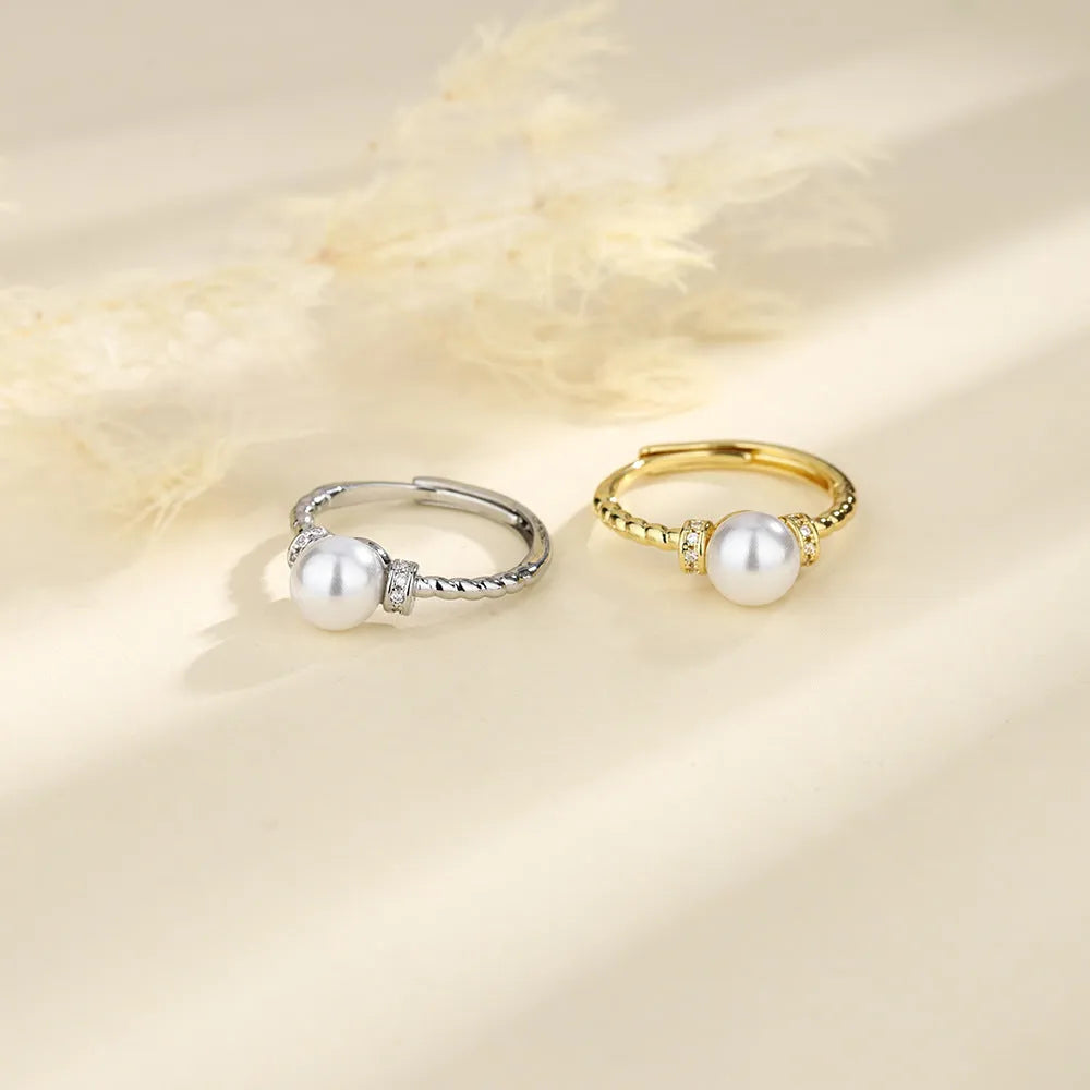 Adjustable copper ring with pearl inlay in gold or silver finish and antique twist design.
