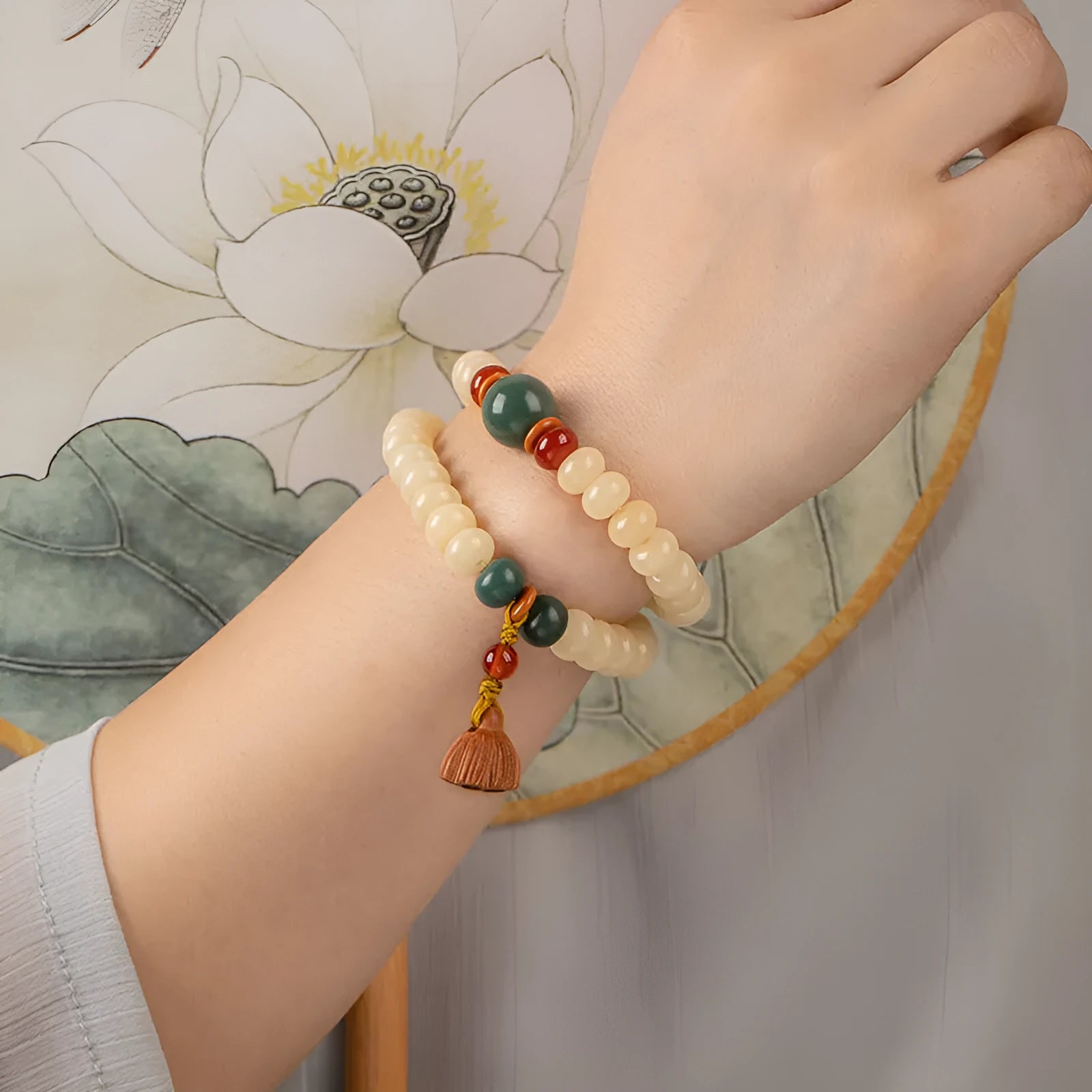 Cream topaz coloured wooden Bodhi root bracelet with flat round beads on a wrist.