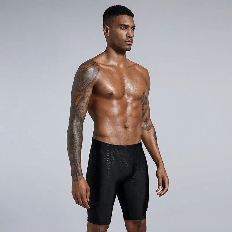 Men's solid colour swimming trunks in shark skin polyester fabric for surfing.