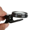 Smartphone macro close-up lens with aluminium frame and clip attachment on white background.