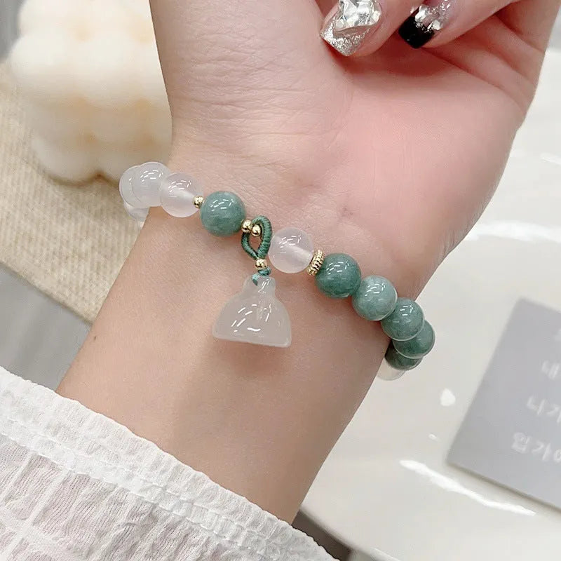 Close-up of a women's retro style agate bracelet with a lotus seedpod design.