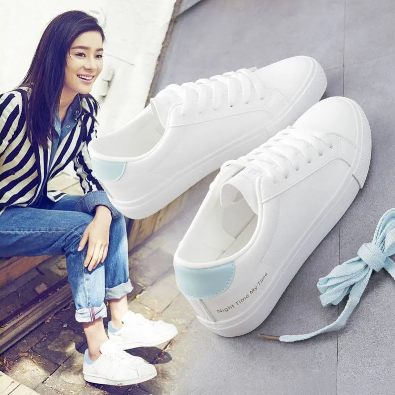 Women's white canvas sneakers with rubber sole and lace-up closure