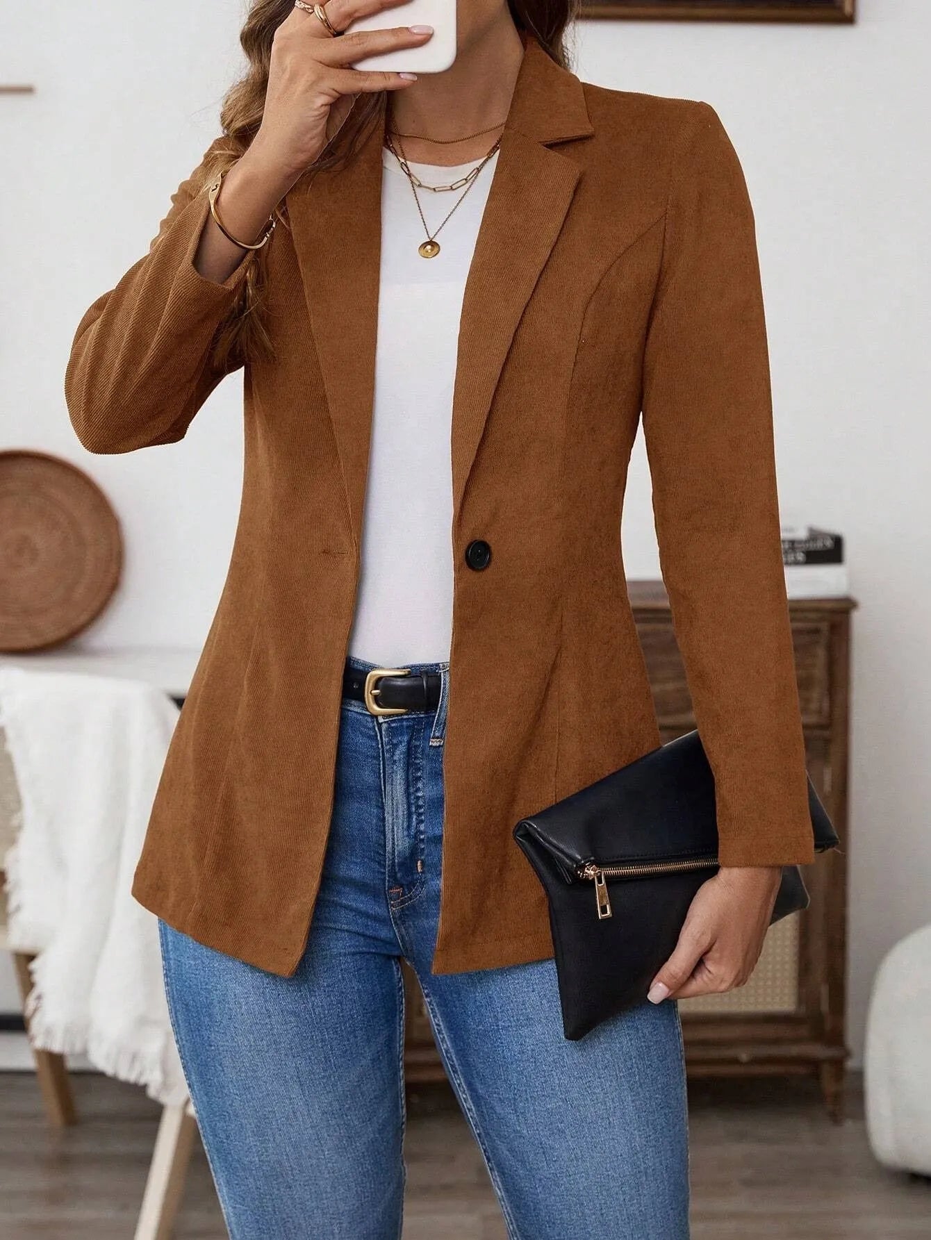 A brown men's single-breasted lapel suit coat with long sleeves on a hanger.