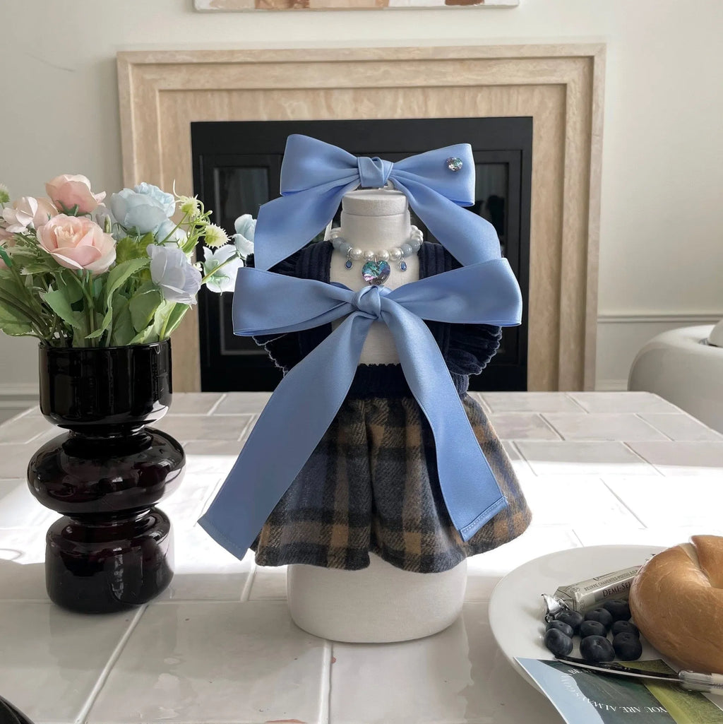 Blue princess-style adjustable bow hair band for dogs on a white background.