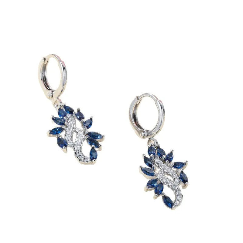 A pair of platinum sapphire blue alloy drop dangle earrings for women on a plain background.