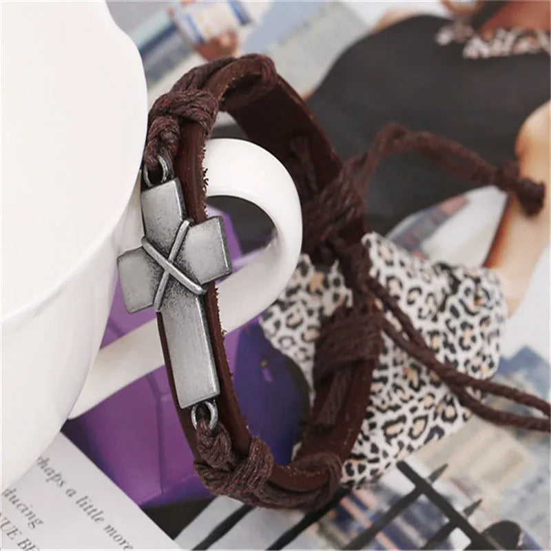 Brown leather cross bracelet with alloy accent, adjustable drawstring, vintage style on wrist