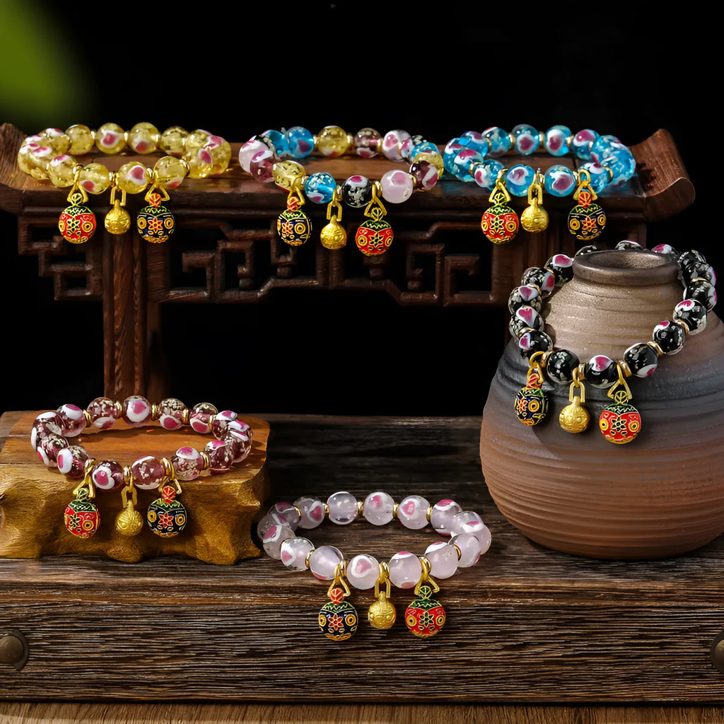 Glass bracelet with 10mm heart beads featuring ancient swallowing gold beast design in multiple colours