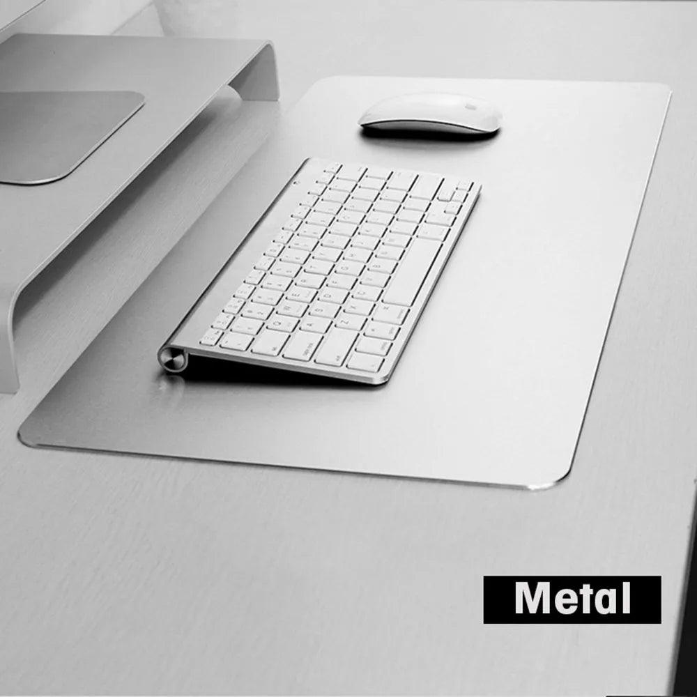 Black aluminium alloy double-sided mouse pad on a desk with a computer mouse on top