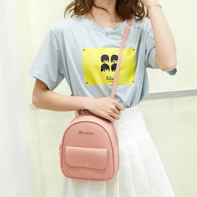 Compact black PU leather women's small backpack with a slim profile and zipper closure.