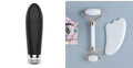 White jade facial roller with double heads and a matching gua sha scraping board on a plain surface.