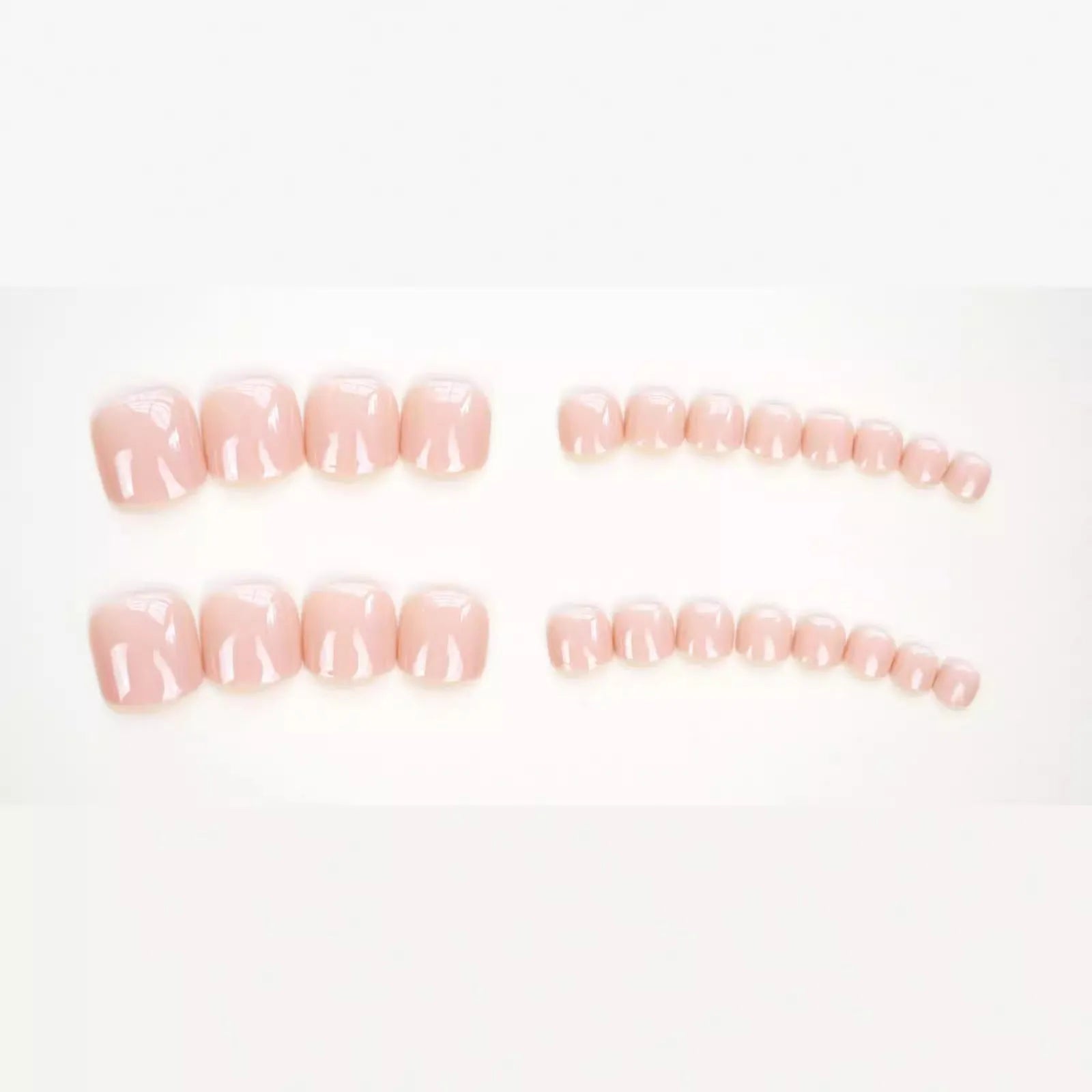 Finished plastic toe nail stickers in J-52 skin colour with glue tube on white background.