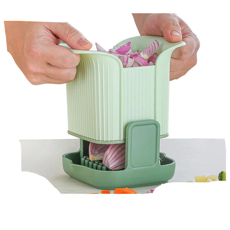 Green multifunctional vegetable chopper with stainless steel blades for dicing onions and slicing cucumbers.