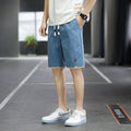 Man wearing loose-fitting straight-leg beach shorts in a khaki colour, showing Korean style and casual fit.