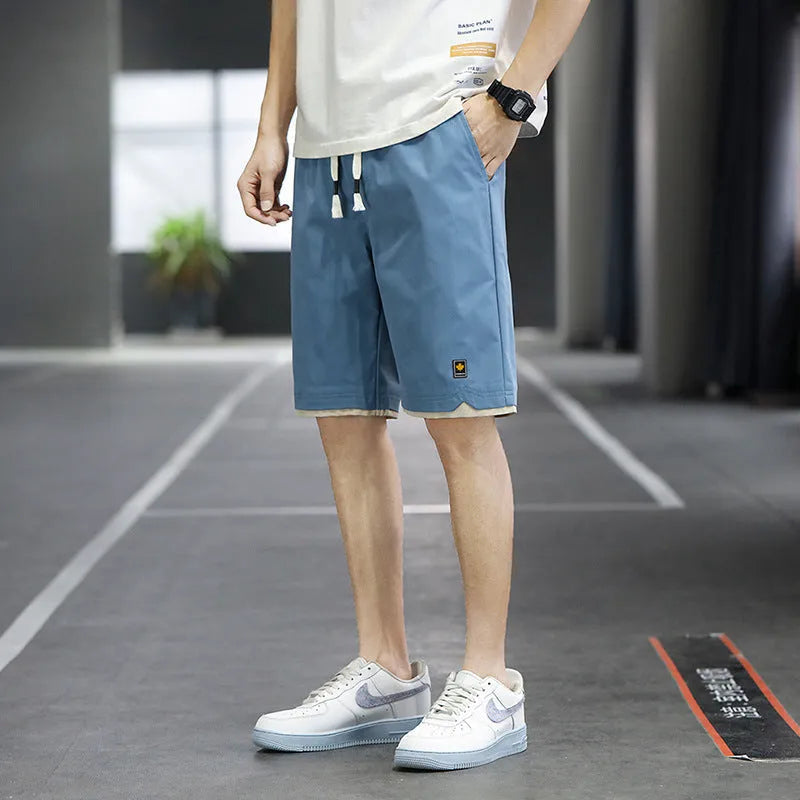 Man wearing loose-fitting straight-leg beach shorts in a khaki colour, showing Korean style and casual fit.