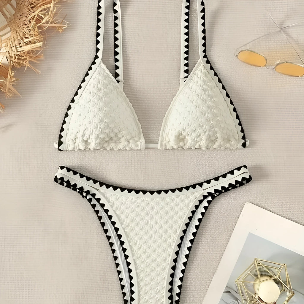 Women's blue and white polyester bikini swimsuit set with briefs style on hanger.
