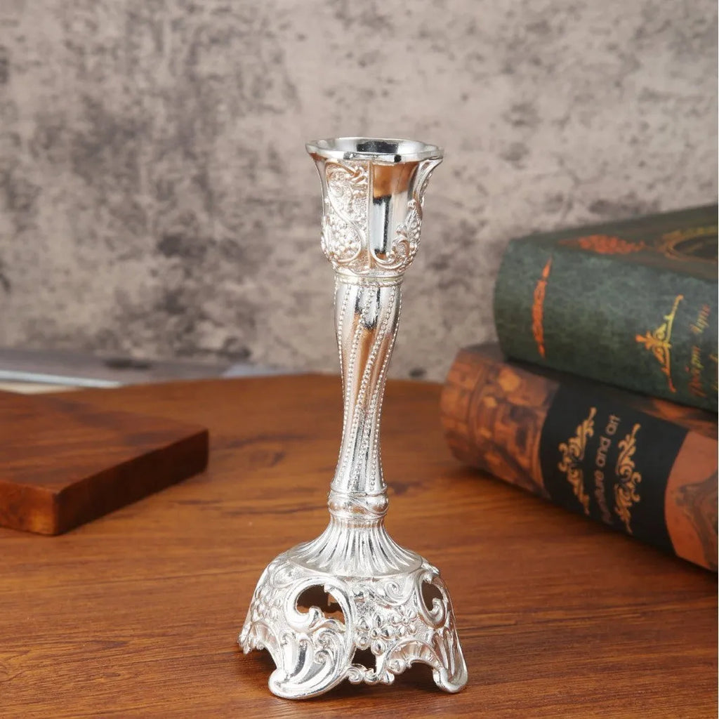Small metal retro candlestick ornament in gold finish on a table
