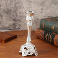Small metal retro candlestick ornament in gold finish on a table