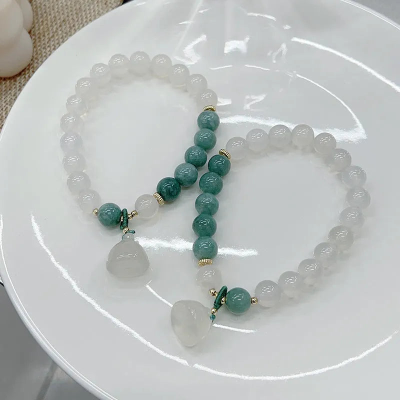 Close-up of a women's retro style agate bracelet with a lotus seedpod design.