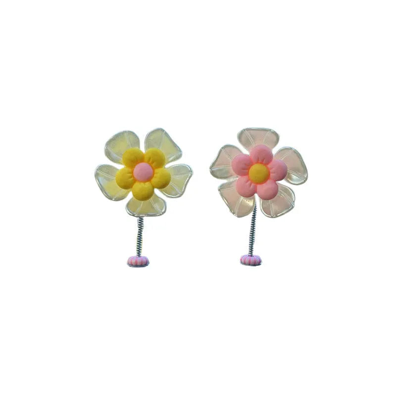 Small colourful plastic car decoration shaped like a swing, shown in multiple colour options.
