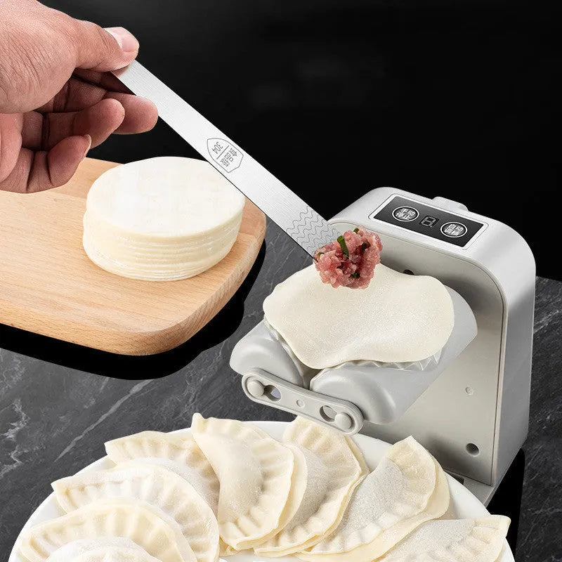 White electric dumpling maker machine with USB charging cable and accessories on kitchen counter