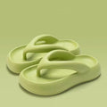 A pair of solid colour thick-soled EVA flip-flops with a bow detail, shown on a light background.