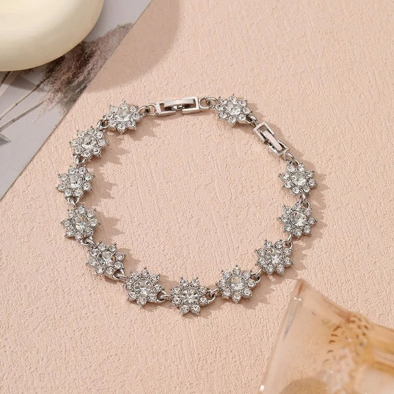 Electroplated zinc alloy flower bracelet with coloured crystals in gold or silver finish.